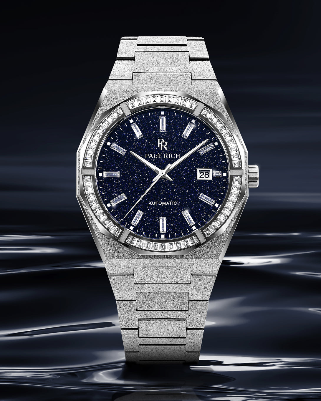 Silver frosted watch with blue aventurine dial and moissanite bezel shown upright against a dark reflective background resembling liquid metal. Quartz | Automatic product_visual Silver frosted watch with blue aventurine dial and moissanite bezel shown upright against a dark reflective background resembling liquid metal. Quartz | Automatic product_visual