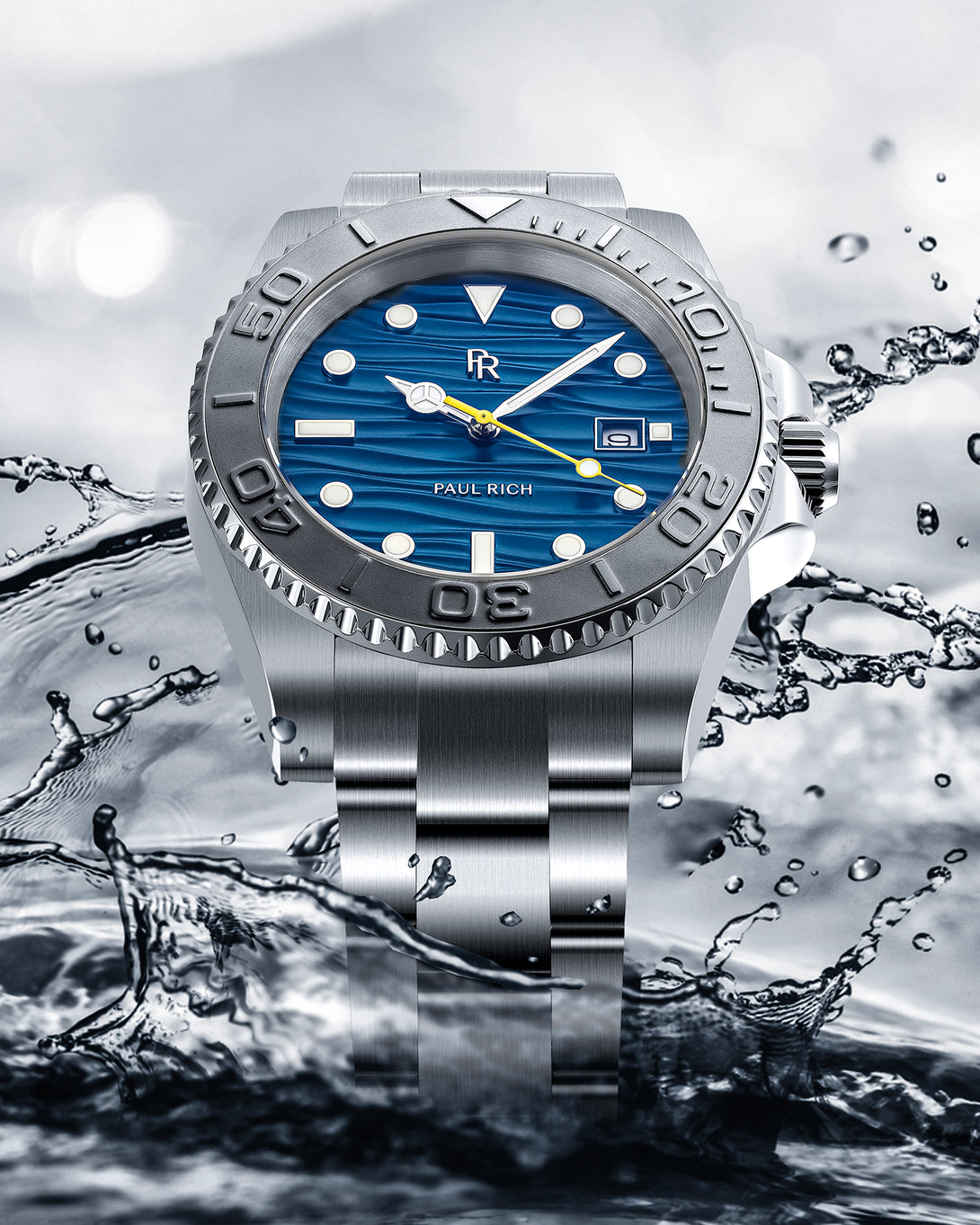 Stainless steel watch with a blue wave-textured dial shown against splashing water, highlighting the bezel, bracelet, and yellow seconds hand. product_visual Stainless steel watch with a blue wave-textured dial shown against splashing water, highlighting the bezel, bracelet, and yellow seconds hand. product_visual