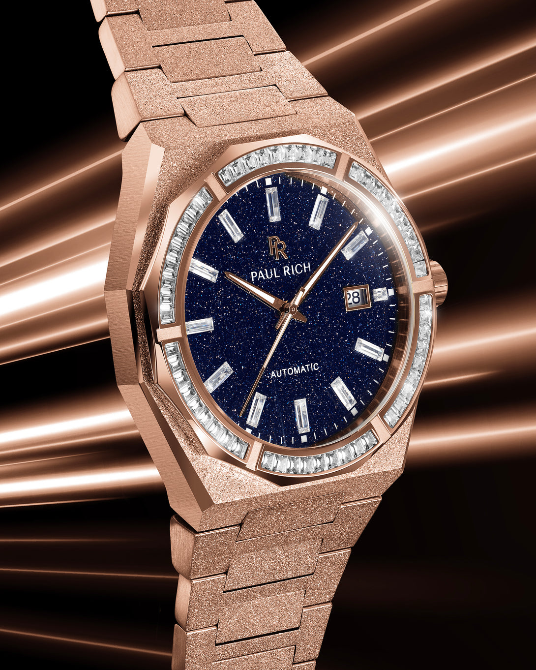 Close-up of a rose gold Paul Rich watch with a blue aventurine dial and gem-set bezel, glowing under warm streaks of light. product_visual Quartz | Automatic