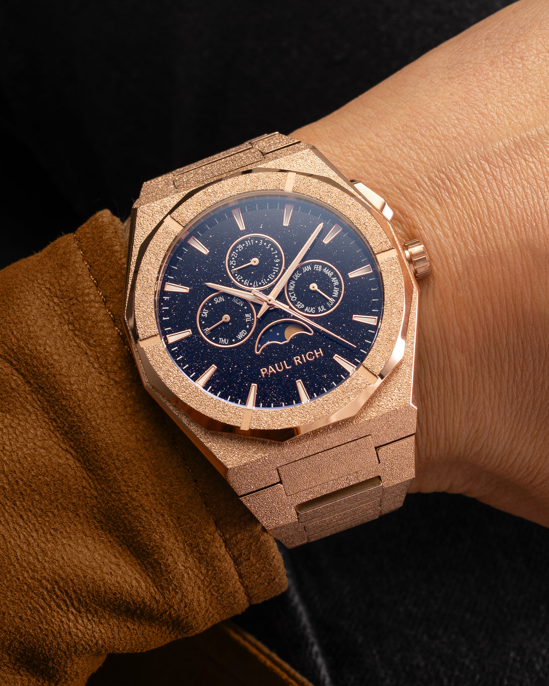 Frosted rose gold moonphase watch on wrist with aventurine dial, calendar subdials, and sparkling textured rose gold bracelet. product_visual, [lifestyle]