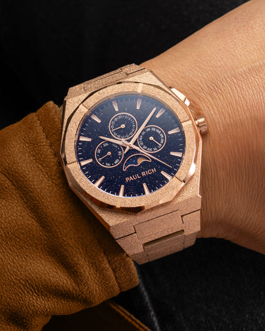 Frosted rose gold moonphase watch on wrist with aventurine dial, calendar subdials, and sparkling textured rose gold bracelet. product_visual, [lifestyle]