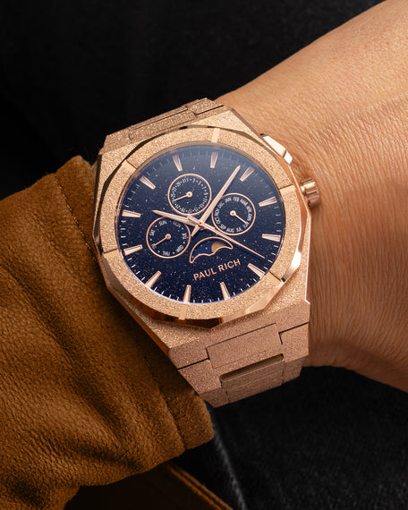 Frosted rose gold moonphase watch on wrist with aventurine dial, calendar subdials, and sparkling textured rose gold bracelet. product_visual, [lifestyle]