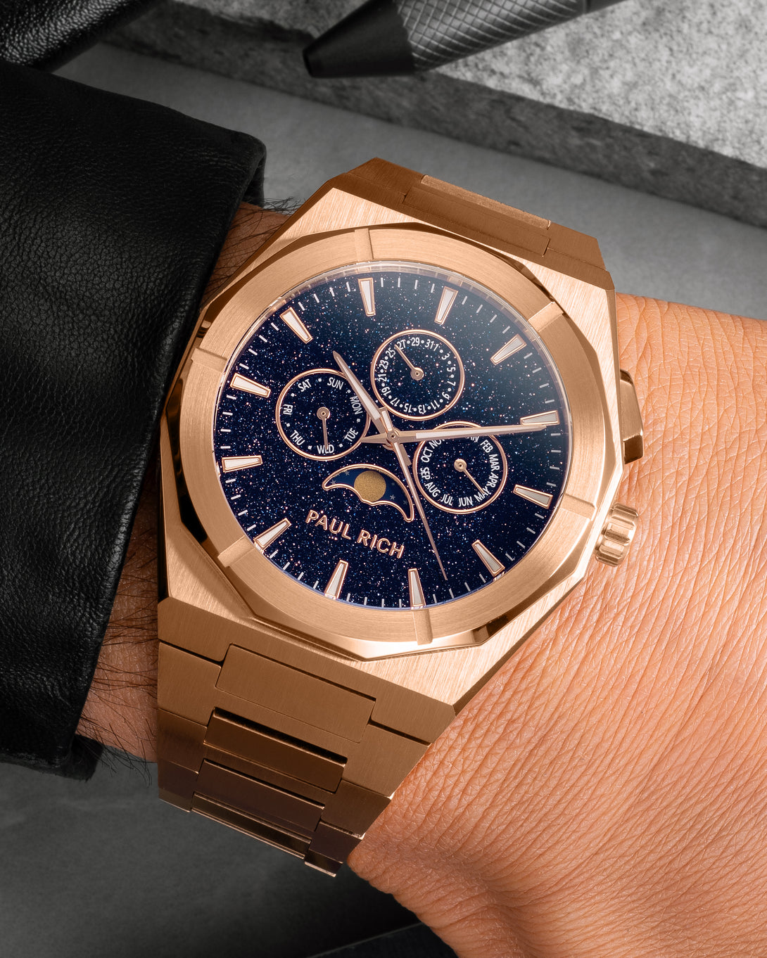 Brushed rose gold moonphase watch on wrist with aventurine dial, calendar subdials, and rose gold bracelet. product_visual, [lifestyle]