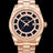 Rose-gold watch with a blue aventurine dial, day and date windows, and a bezel and hour markers set with clear stones on a full rose-gold bracelet.