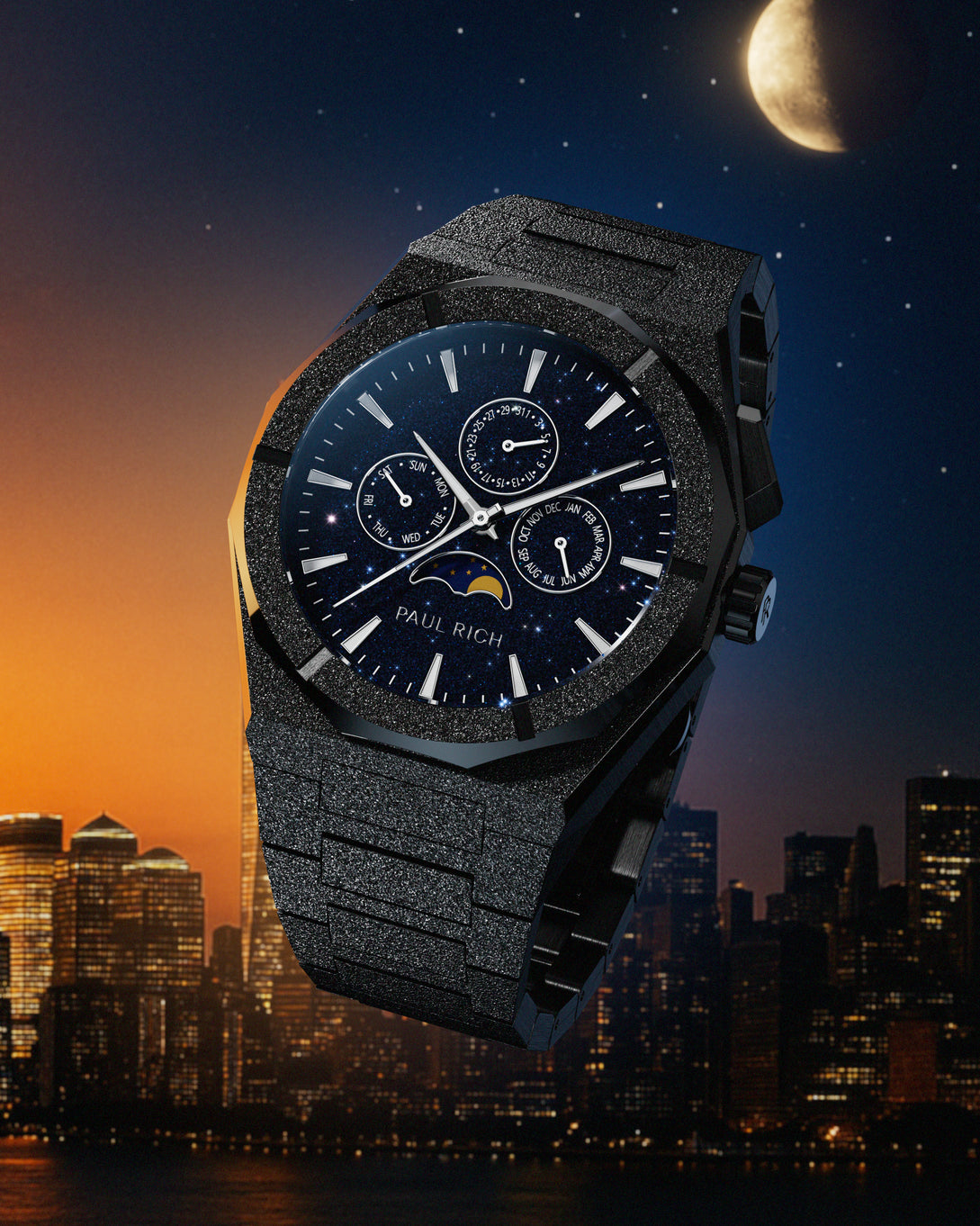 Frosted black stainless steel watch with blue aventurine dial, moonphase, and subdials, set against a city skyline at dusk with a moonlit sky. product_visual
