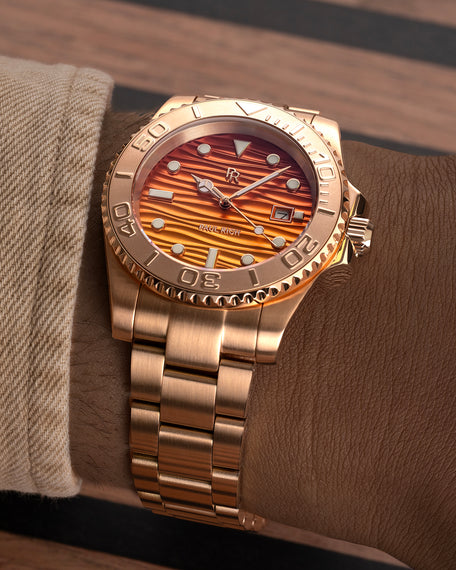 Rose-gold stainless steel watch with an orange wave-textured dial shown on a wrist, highlighting the bracelet, bezel, and dial details. [lifestyle] product_visual